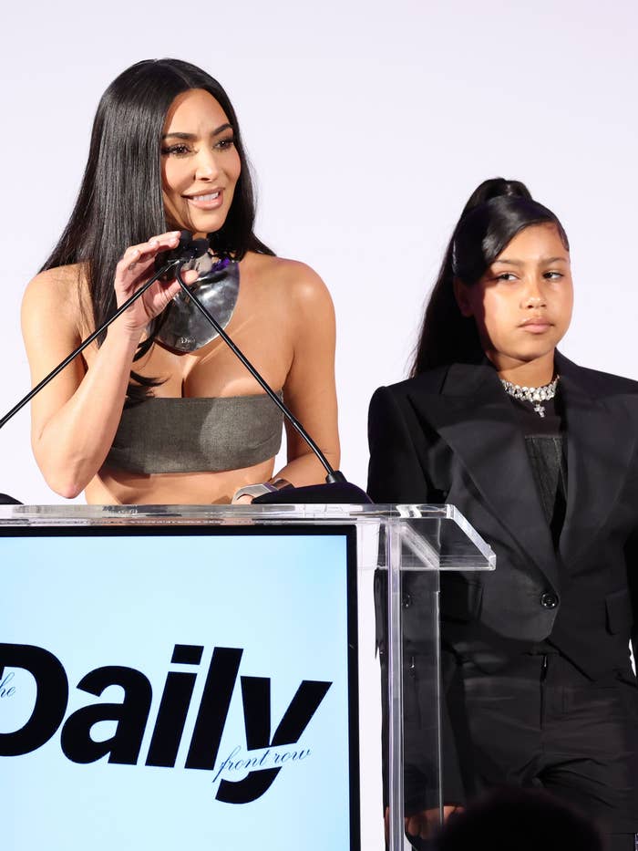 Kim speaks at a podium as North West looks on